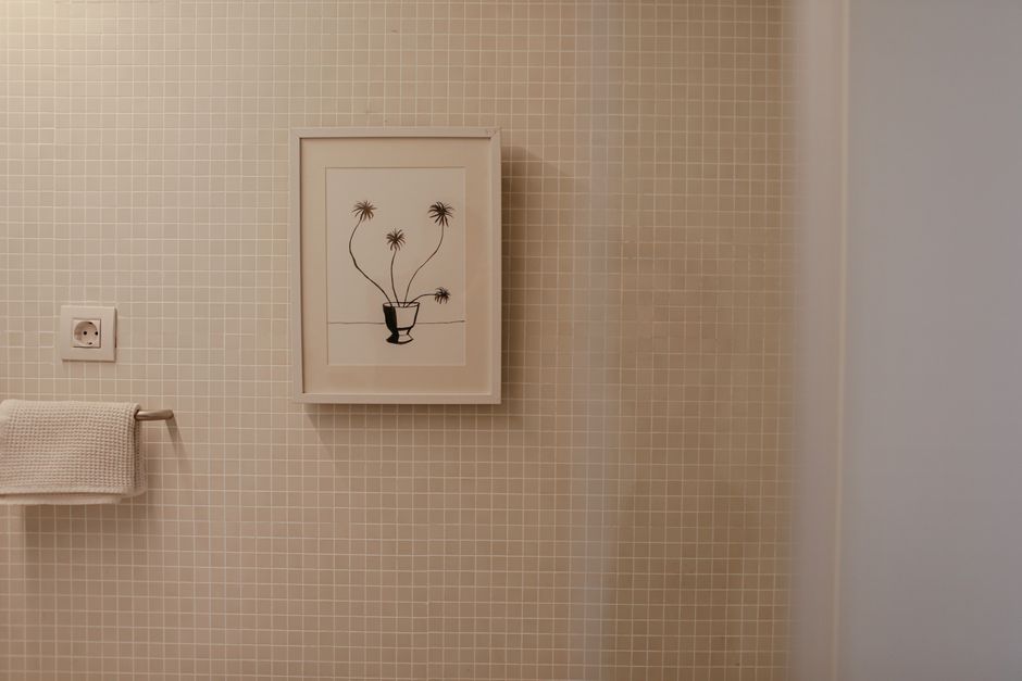 Minimalistische spiegel met houten lijst in badkamer.